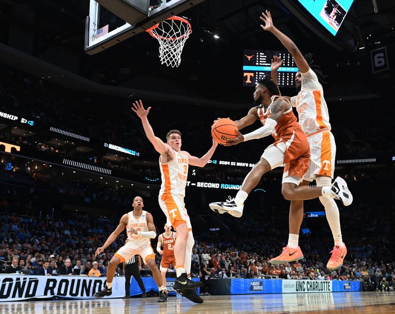 March 23, 2024, Charlotte, NC, USA; Texas Longhorns guard Tyrese Hunter (4) passes the ball away from Tennessee Volunteers forward Jonas Aidoo (0) and Tennessee Volunteers guard Dalton Knecht (3) in the second round of the 2024 NCAA Tournament at the Spectrum Center. Mandatory Credit: Bob Donnan-USA TODAY Sports