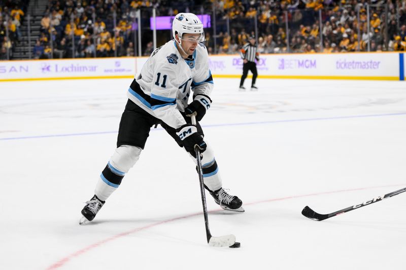 Nov 9, 2024; Nashville, Tennessee, USA;  Utah Hockey Club right wing Dylan Guenther (11) skates with the puck against against the Nashville Predators during the second period at Bridgestone Arena. Mandatory Credit: Steve Roberts-Imagn Images