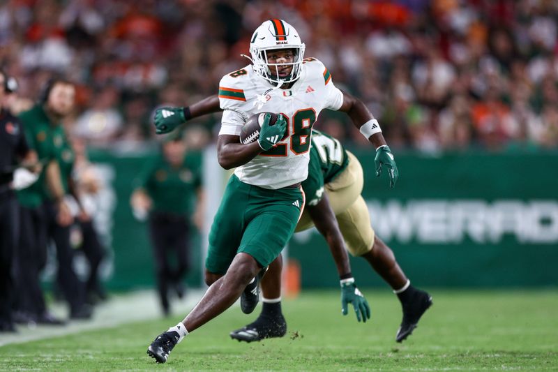 Sep 21, 2024; Tampa, Florida, USA;  Miami Hurricanes running back Ajay Allen (28) runs with the ball against the South Florida Bulls in the third quarter at Raymond James Stadium. Mandatory Credit: Nathan Ray Seebeck-Imagn Images