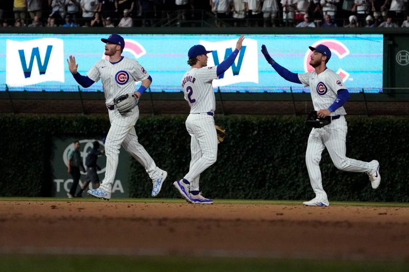 Jun 18, 2024; Chicago, Illinois, USA; Chicago Cubs L-R Ian Happ second baseman Nico Hoerner and outfielder Cody Bellinger (24) celebrate their win against the San Francisco Giants at Wrigley Field. Mandatory Credit: David Banks-USA TODAY Sports