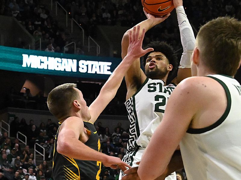 Feb 20, 2024; East Lansing, Michigan, USA;  Michigan State Spartans forward Malik Hall (25) shoots over Iowa Hawkeyes forward Patrick McCaffery (22) during the second half at Jack Breslin Student Events Center. Mandatory Credit: Dale Young-USA TODAY Sports
