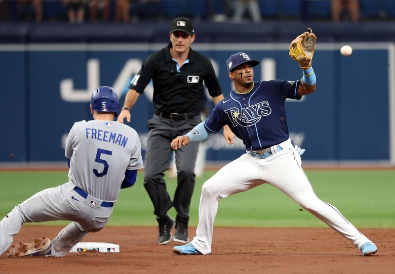 May 27, 2023; St. Petersburg, Florida, USA;  Los Angeles Dodgers first baseman Freddie Freeman (5) doubles as Tampa Bay Rays shortstop Wander Franco (5) attempted to tag him out during the third inning against the Tampa Bay Rays at Tropicana Field. Mandatory Credit: Kim Klement-USA TODAY Sports