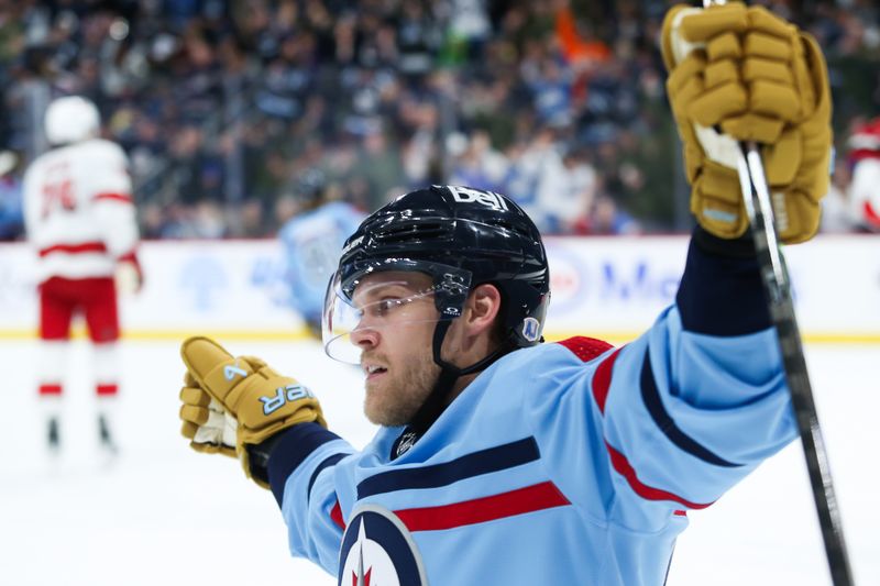 Dec 4, 2023; Winnipeg, Manitoba, CAN; Winnipeg Jets forward Nikolaj Ehlers (27) celebrates his goal against Carolina Hurricanes goalie Antti Raanta (32) during the second period at Canada Life Centre. Mandatory Credit: Terrence Lee-USA TODAY Sports