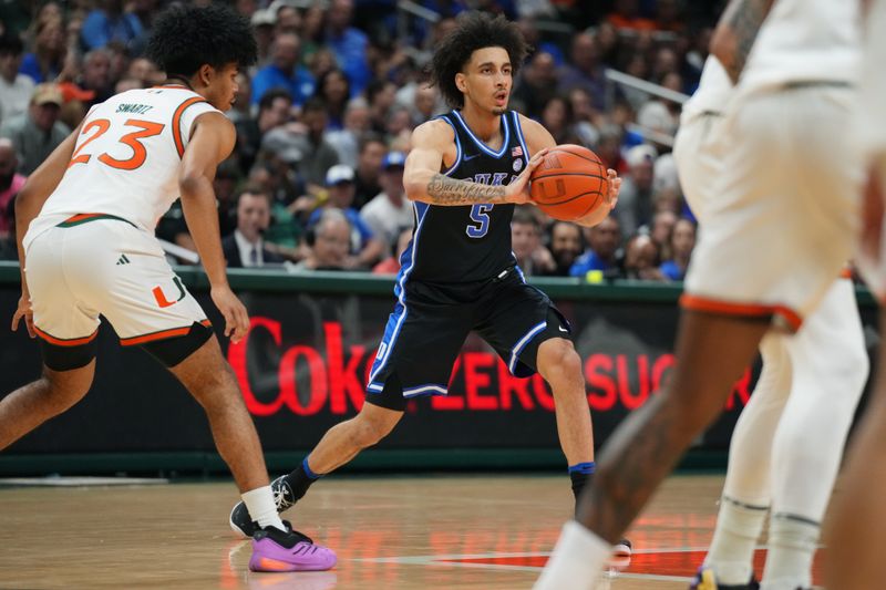 Feb 25, 2025; Coral Gables, Florida, USA;  Duke Blue Devils guard Tyrese Proctor (5) passes the ball as Miami (Fl) Hurricanes guard Austin Swartz (23) defends during the first half at Watsco Center. Mandatory Credit: Jim Rassol-Imagn Images