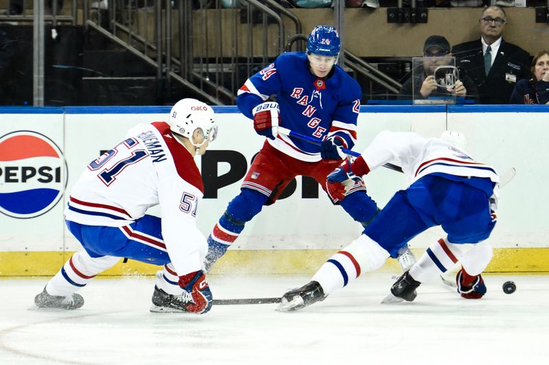 Nov 30, 2024; New York, New York, USA; New York Rangers right wing Kaapo Kakko (24) skates with the puck against Montreal Canadiens left wing Emil Heineman (51) and Montreal Canadiens center Jake Evans (71) during the first period at Madison Square Garden. Mandatory Credit: John Jones-Imagn Images