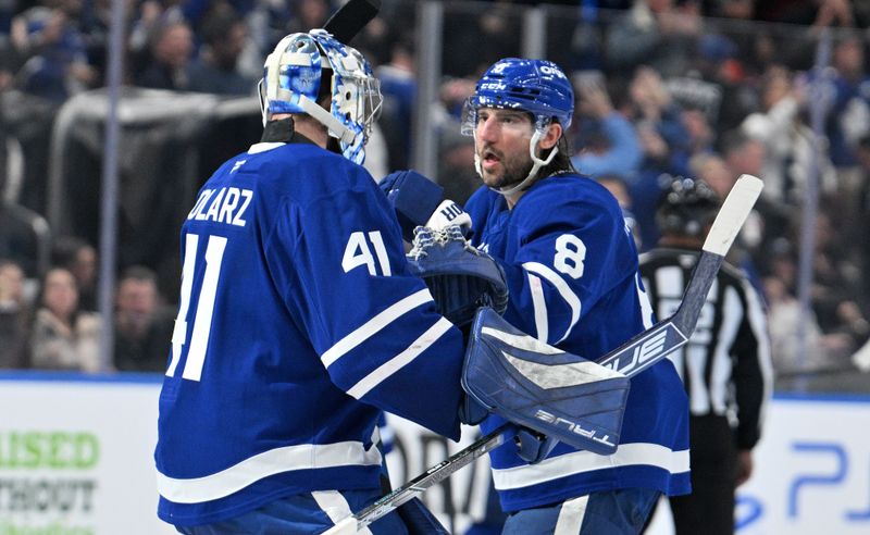 Nov 16, 2024; Toronto, Ontario, CAN;  Toronto Maple Leafs defenseman Chris Tanev (8) congratulates goalie Anthony Stolarz (41) after an overtime victory against the Edmonton Oilers at Scotiabank Arena. Mandatory Credit: Dan Hamilton-Imagn Images