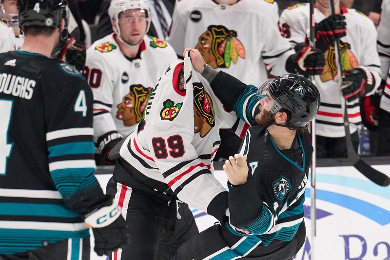 Mar 23, 2024; San Jose, California, USA; San Jose Sharks center Luke Kunin (11) fights against Chicago Blackhawks center Andreas Athanasiou (89) during the first period at SAP Center at San Jose. Mandatory Credit: Robert Edwards-USA TODAY Sports