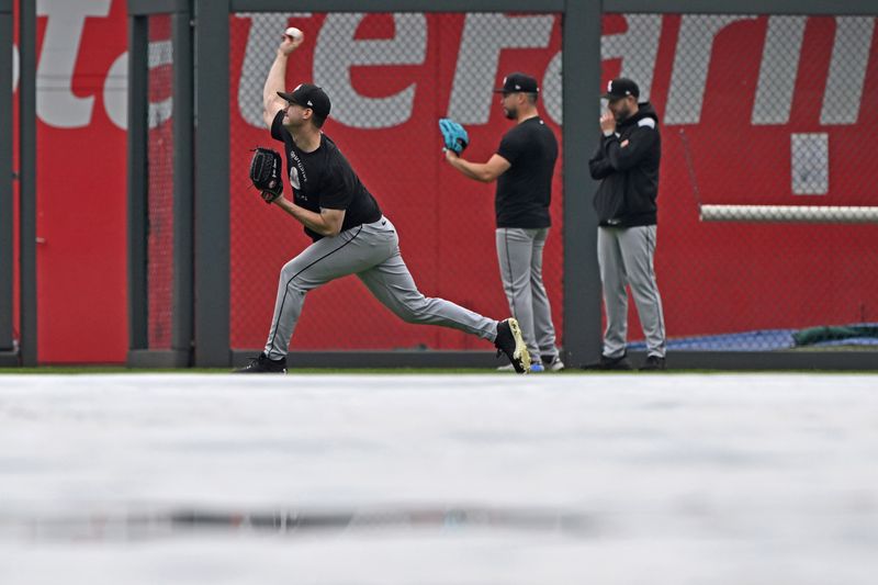 May 7, 2025; Kansas City, Missouri, USA;  Chicago White Sox players warm up with the tarp on the field, before a game against the Kansas City Royals at Kauffman Stadium. Mandatory Credit: Peter Aiken-Imagn Images