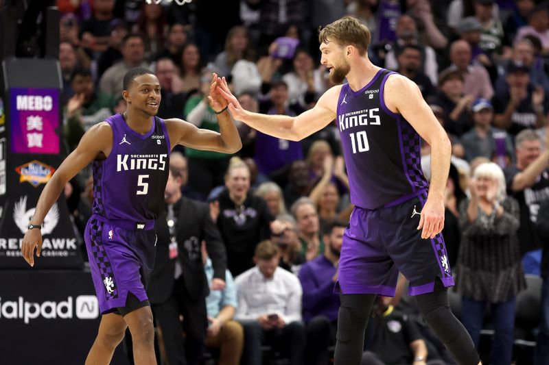 SACRAMENTO, CALIFORNIA - MARCH 12: Domantas Sabonis #10 high-fives De'Aaron Fox #5 of the Sacramento Kings during their game against the Milwaukee Bucks at Golden 1 Center on March 12, 2024 in Sacramento, California. NOTE TO USER: User expressly acknowledges and agrees that, by downloading and or using this photograph, User is consenting to the terms and conditions of the Getty Images License Agreement.  (Photo by Ezra Shaw/Getty Images)