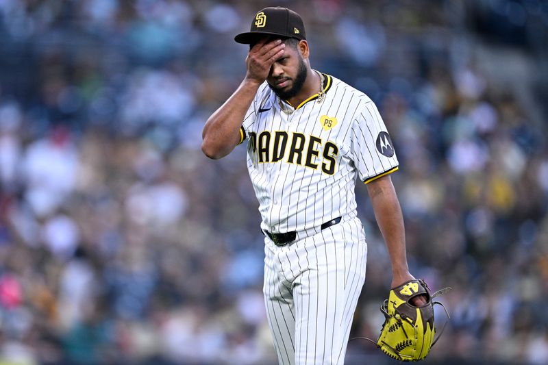 May 13, 2024; San Diego, California, USA; San Diego Padres starting pitcher Randy Vasquez (98) wipes his face while walking to the dugout during the middle of the second inning against the Colorado Rockies at Petco Park. Mandatory Credit: Orlando Ramirez-USA TODAY Sports