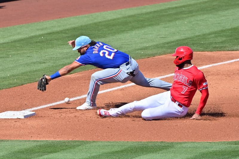 Mar 11, 2024; Tempe, Arizona, USA;  Los Angeles Angels right fielder Jo Adell (7) steals third base as Texas Rangers shortstop Ezequiel Duran (20) misses the ball in the second inning during a spring training game at Tempe Diablo Stadium. Mandatory Credit: Matt Kartozian-USA TODAY Sports