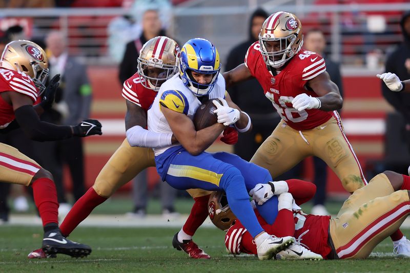 Los Angeles Rams wide receiver Puka Nacua, middle, is tackled after catching a pass against the San Francisco 49ers during the second half of an NFL football game in Santa Clara, Calif., Sunday, Jan. 7, 2024. Nacua set a rookie record for receiving yards on this play. (AP Photo/Jed Jacobsohn)