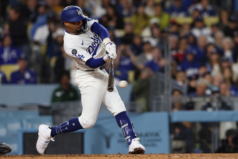 Apr 28, 2025; Los Angeles, California, USA; Los Angeles Dodgers shortstop Mookie Betts (50) hits an RBI single in the third inning against the Miami Marlins at Dodger Stadium. Mandatory Credit: Jason Parkhurst-Imagn Images