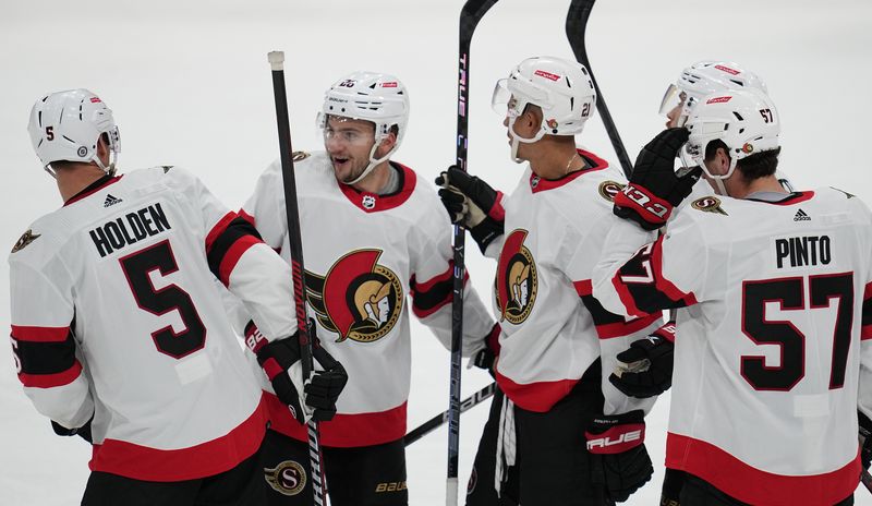 Oct 29, 2022; Sunrise, Florida, USA; Ottawa Senators defenseman Nick Holden (5) celebrates a goal against the Florida Panthers with teammates defenseman Erik Brannstrom (26), right wing Mathieu Joseph (21) and  center Shane Pinto (57) at FLA Live Arena. Mandatory Credit: Jim Rassol-USA TODAY Sports