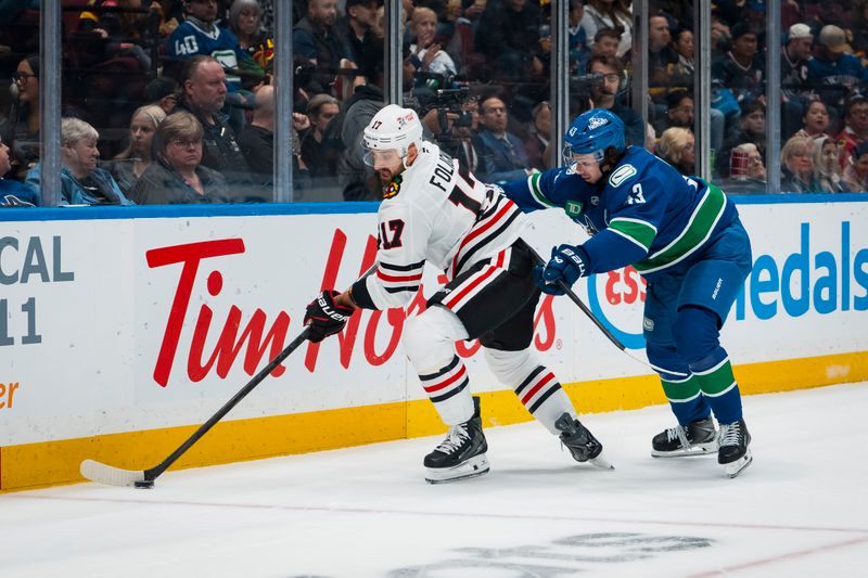 Nov 5, 2025; Vancouver, British Columbia, CAN; Vancouver Canucks defenseman Quinn Hughes (43) checks Chicago Blackhawks forward Nick Foligno (17) in the first period at Rogers Arena. Mandatory Credit: Bob Frid-Imagn Images