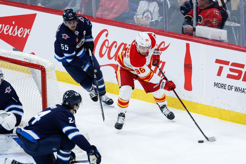 Jan 26, 2025; Winnipeg, Manitoba, CAN;  Calgary Flames forward Andrei Kuzmenko (96) skates away from Winnipeg Jets forward Mark Scheifele (55) during the third period at Canada Life Centre. Mandatory Credit: Terrence Lee-Imagn Images