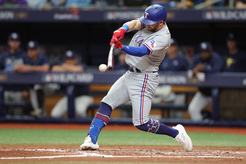 Oct 4, 2023; St. Petersburg, Florida, USA; Texas Rangers shortstop Corey Seager (5) hits a single against the Tampa Bay Rays in the fifth inning during game two of the Wildcard series for the 2023 MLB playoffs at Tropicana Field. Mandatory Credit: Nathan Ray Seebeck-USA TODAY Sports