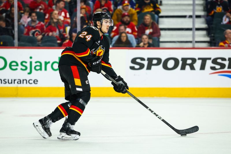 Dec 31, 2024; Calgary, Alberta, CAN; Calgary Flames defenseman Jake Bean (24) controls the puck against the Vancouver Canucks during the third period at Scotiabank Saddledome. Mandatory Credit: Sergei Belski-Imagn Images