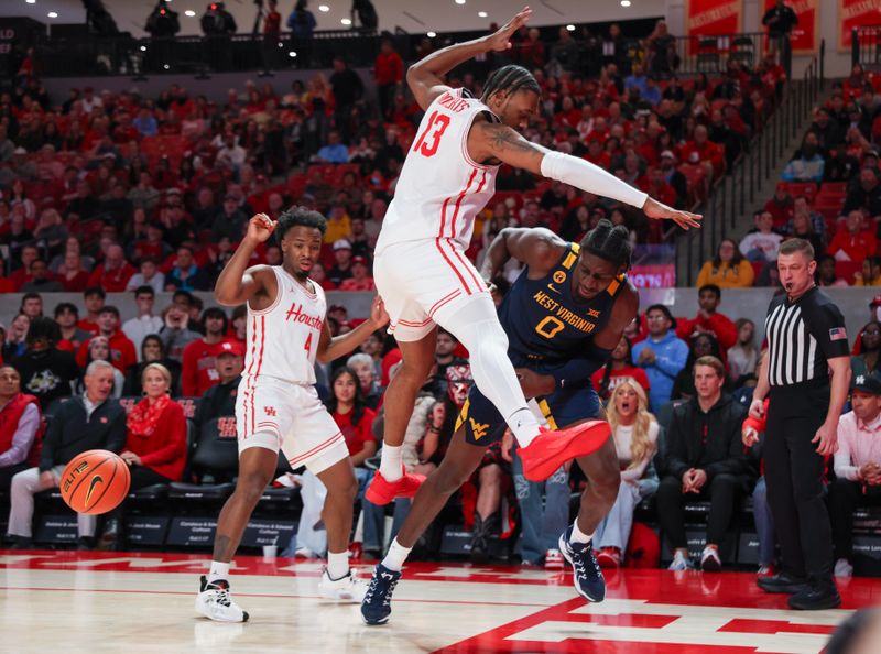 Jan 15, 2025; Houston, Texas, USA; West Virginia Mountaineers center Eduardo Andre (0) passes between Houston Cougars forward J'Wan Roberts (13) legs  in the first half at Fertitta Center. Mandatory Credit: Thomas Shea-Imagn Images