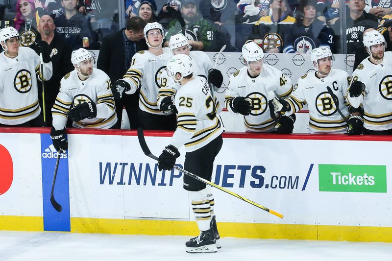 Dec 22, 2023; Winnipeg, Manitoba, CAN;  Boston Bruins defenseman Brandon Carlo (25) is congratulated by his team mates on his goal against the Winnipeg Jets during the third period at Canada Life Centre. Mandatory Credit: Terrence Lee-USA TODAY Sports