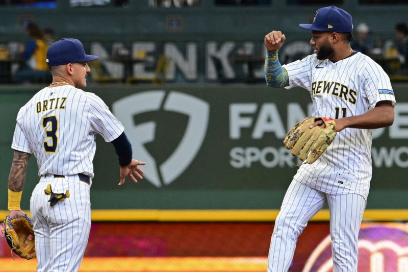 Apr 6, 2025; Milwaukee, Wisconsin, USA;  Milwaukee Brewers left fielder Jackson Chourio (11) celebrate with  shortstop Joseph Ortiz (3) after beating the Cincinnati Reds at American Family Field. Mandatory Credit: Benny Sieu-Imagn Images