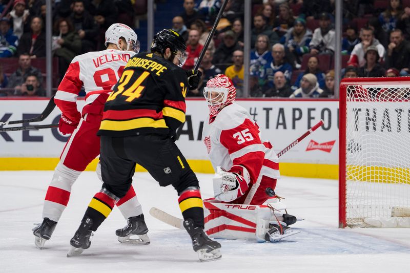 Feb 13, 2023; Vancouver, British Columbia, CAN; Detroit Red Wings forward Joe Veleno (90) and goalie Ville Husso (35) and Vancouver Canucks forward Phillip Di Giuseppe (34) watch the puck bounce off the post in the first period at Rogers Arena. Mandatory Credit: Bob Frid-USA TODAY Sports