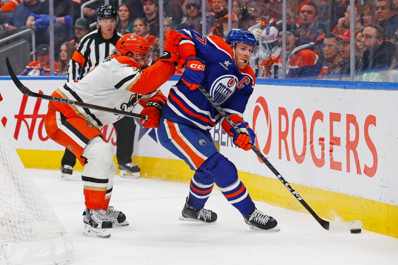 Jan 3, 2025; Edmonton, Alberta, CAN; Edmonton Oilers forward Connor McDavid (97) and Anaheim Ducks defensemen Radko Gudas (7) battle along the boards for a loose puck during the third period at Rogers Place. Mandatory Credit: Perry Nelson-Imagn Images