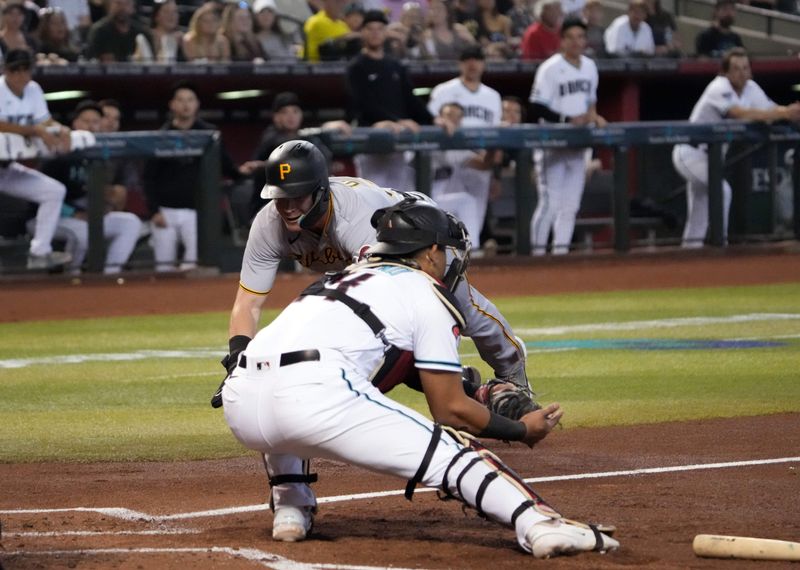 Jul 8, 2023; Phoenix, Arizona, USA; Pittsburgh Pirates catcher Henry Davis (32) is unable to beat a throw to Arizona Diamondbacks catcher Gabriel Moreno (14) and is tagged out at home during the third inning at Chase Field. Mandatory Credit: Joe Camporeale-USA TODAY Sports