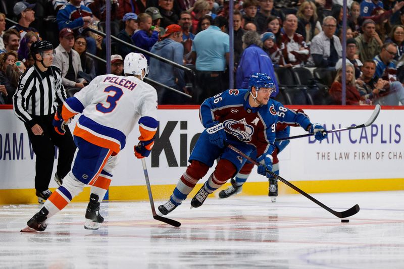 Oct 14, 2024; Denver, Colorado, USA; Colorado Avalanche right wing Mikko Rantanen (96) controls the puck as New York Islanders defenseman Adam Pelech (3) defends in the second period at Ball Arena. Mandatory Credit: Isaiah J. Downing-Imagn Images