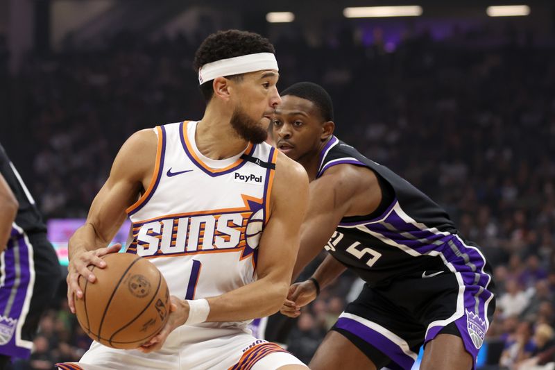 SACRAMENTO, CALIFORNIA - NOVEMBER 13: Devin Booker #1 of the Phoenix Suns is guarded by De'Aaron Fox #5 of the Sacramento Kings in the first half at Golden 1 Center on November 13, 2024 in Sacramento, California. NOTE TO USER: User expressly acknowledges and agrees that, by downloading and/or using this photograph, user is consenting to the terms and conditions of the Getty Images License Agreement.  (Photo by Ezra Shaw/Getty Images)