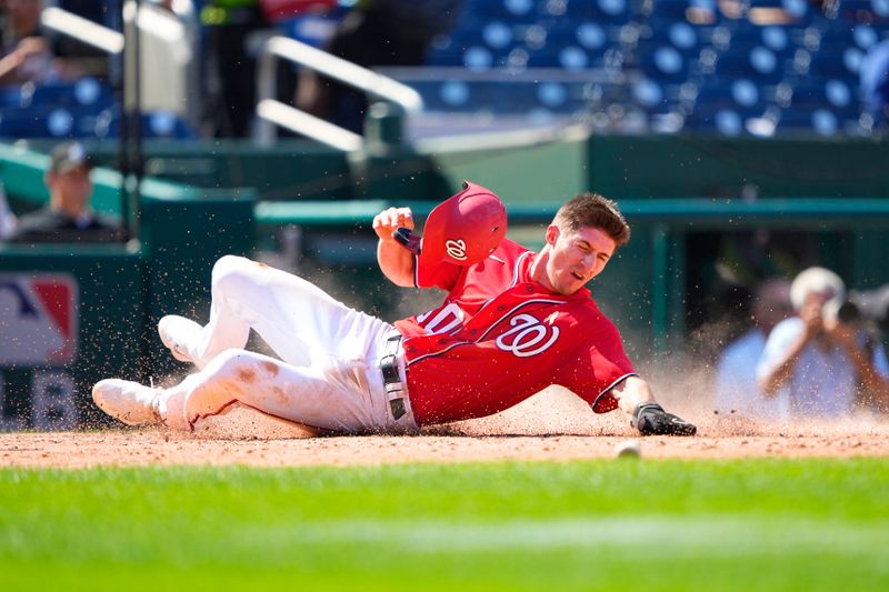 Sep 3, 2023; Washington, District of Columbia, USA;  Washington Nationals center fielder Jacob Young (30) slides safely into home plate on Washington Nationals right fielder Lane Thomas (not pictured) RBI single against the Miami Marlins during the fifth inning at Nationals Park. Mandatory Credit: Gregory Fisher-USA TODAY Sports