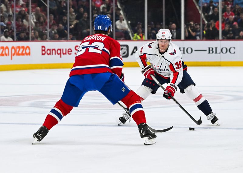 Oct 21, 2023; Montreal, Quebec, CAN; Washington Capitals defenseman Rasmus Sandin (38) plays the puck against Montreal Canadiens defenseman Justin Barron (52) during the first period at Bell Centre. Mandatory Credit: David Kirouac-USA TODAY Sports