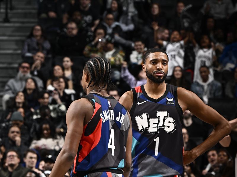BROOKLYN, NY - JANUARY 27: Mikal Bridges #1 and Dennis Smith Jr. #4 of the Brooklyn Nets look on during the game against the Houston Rockets on January 27, 2024 at Barclays Center in Brooklyn, New York. NOTE TO USER: User expressly acknowledges and agrees that, by downloading and or using this Photograph, user is consenting to the terms and conditions of the Getty Images License Agreement. Mandatory Copyright Notice: Copyright 2024 NBAE (Photo by David Dow/NBAE via Getty Images)