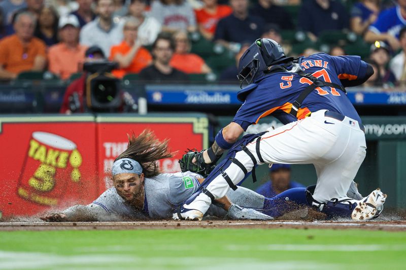 Apr 2, 2024; Houston, Texas, USA; Toronto Blue Jays shortstop Bo Bichette (11) is tagged out by Houston Astros catcher Victor Caratini (17) on a play at the plate during the first inning at Minute Maid Park. Mandatory Credit: Troy Taormina-USA TODAY Sports