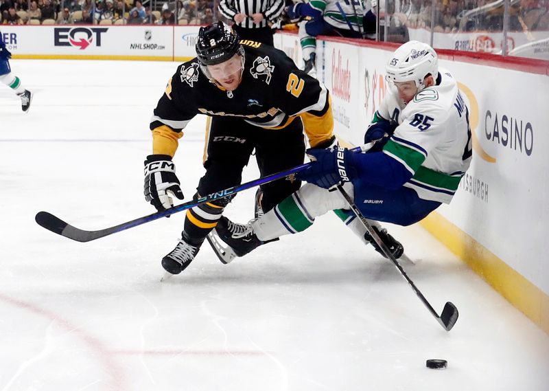 Jan 11, 2024; Pittsburgh, Pennsylvania, USA; Pittsburgh Penguins defenseman Chad Ruhwedel (2) checks Vancouver Canucks right wing Ilya Mikheyev (65) off of the puck during the second period at PPG Paints Arena. Mandatory Credit: Charles LeClaire-USA TODAY Sports