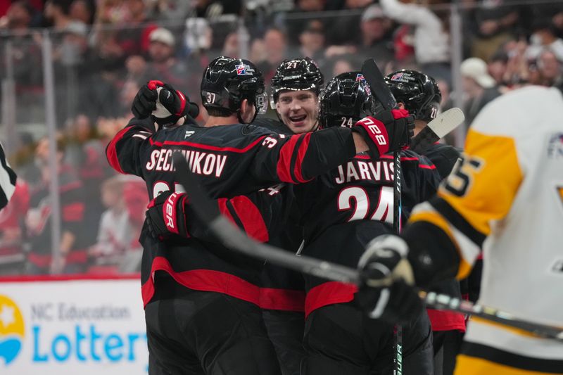 Mar 10, 2026; Raleigh, North Carolina, USA;  Carolina Hurricanes defenseman Alexander Nikishin (21) is congratulated by right wing Andrei Svechnikov (37) center Seth Jarvis (24) and left wing Nikolaj Ehlers (27) after his goal against the Pittsburgh Penguins during the third period at Lenovo Center. Mandatory Credit: James Guillory-Imagn Images