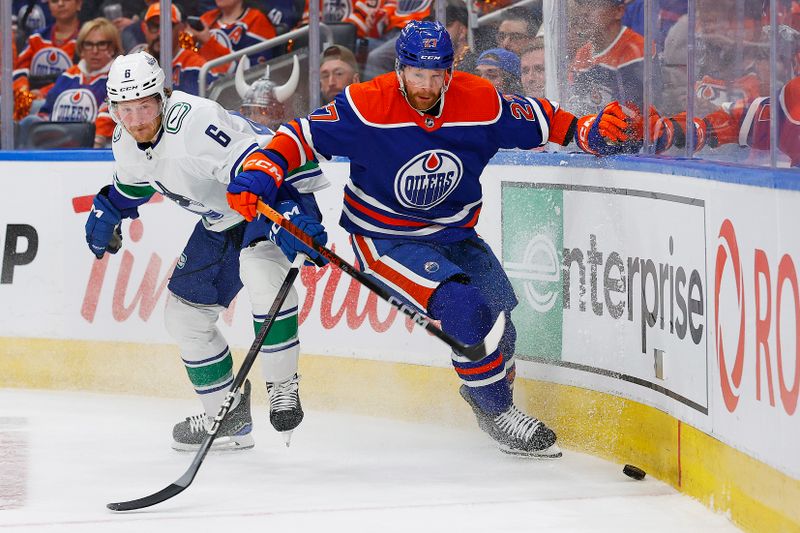 May 14, 2024; Edmonton, Alberta, CAN; Edmonton Oilers defensemen Brett Kulak (27)  and Vancouver Canucks forward Brock Boeser (6) Battle along the boards for a loose puck  during the second period in game four of the second round of the 2024 Stanley Cup Playoffs at Rogers Place. Mandatory Credit: Perry Nelson-USA TODAY Sports