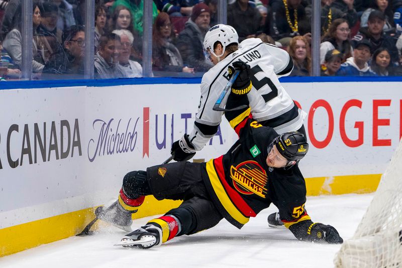 Mar 25, 2024; Vancouver, British Columbia, CAN; Los Angeles Kings defenseman Andreas Englund (5) checks Vancouver Canucks forward Teddy Blueger (53) in the first period at Rogers Arena. Mandatory Credit: Bob Frid-USA TODAY Sports