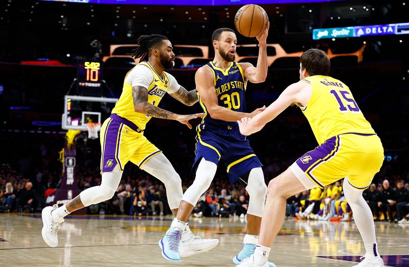 LOS ANGELES, CALIFORNIA - APRIL 09:  Stephen Curry #30 of the Golden State Warriors controls the ball against D'Angelo Russell #1 and Austin Reaves #15 of the Los Angeles Lakers in the second half at Crypto.com Arena on April 09, 2024 in Los Angeles, California.  NOTE TO USER: User expressly acknowledges and agrees that, by downloading and/or using this photograph, user is consenting to the terms and conditions of the Getty Images License Agreement.  (Photo by Ronald Martinez/Getty Images)