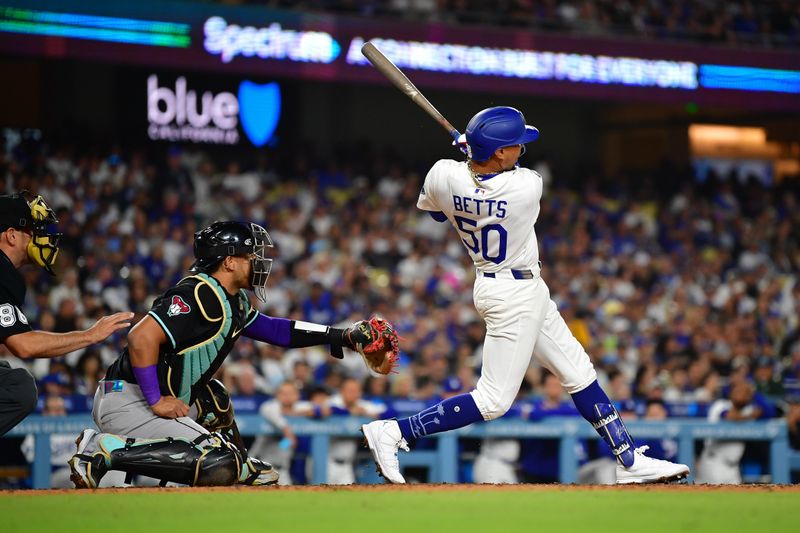 May 19, 2025; Los Angeles, California, USA; Los Angeles Dodgers shortstop Mookie Betts (50) hits a solo home run against the Arizona Diamondbacks during the fourth inning at Dodger Stadium. Mandatory Credit: Gary A. Vasquez-Imagn Images
