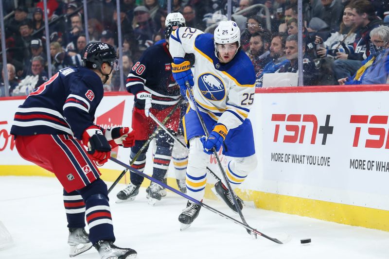 Jan 26, 2023; Winnipeg, Manitoba, CAN;  Buffalo Sabres forward Owen Power (25) tries to evade Winnipeg Jets forward Saku Maenalanen (8) during the second period at Canada Life Centre. Mandatory Credit: Terrence Lee-USA TODAY Sports