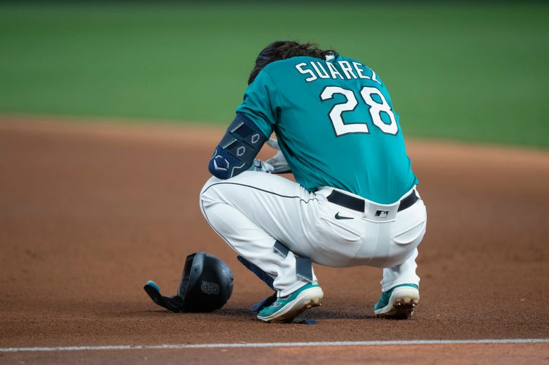 Sep 30, 2023; Seattle, Washington, USA; Seattle Mariners third baseman Eugenio Suarez (28) squats down near first base after making the final out of the fifth inning against the Texas Rangers at T-Mobile Park. Mandatory Credit: Stephen Brashear-USA TODAY Sports