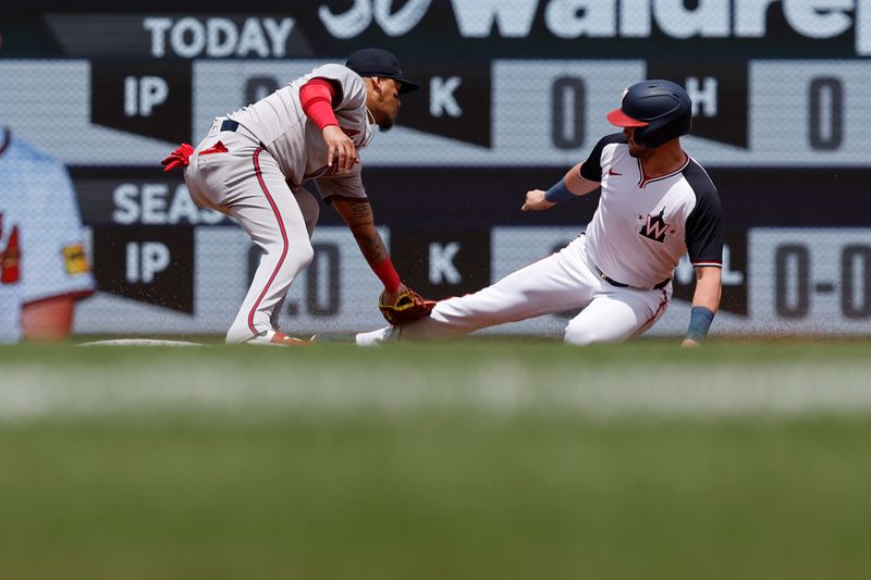 Jun 9, 2024; Washington, District of Columbia, USA; Atlanta Braves shortstop Orlando Arcia (11) tags out Washington Nationals right fielder Lane Thomas (28) on a steal attempt at second base during the first inning at Nationals Park. Mandatory Credit: Geoff Burke-USA TODAY Sports