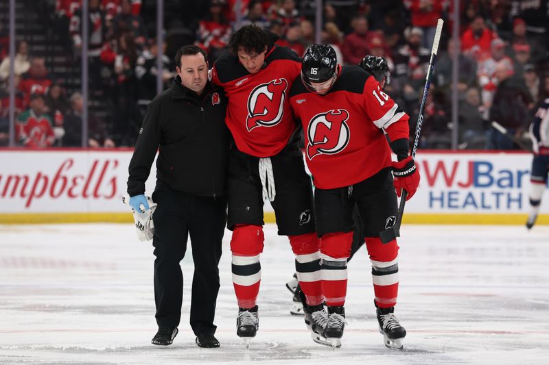 Dec 1, 2025; Newark, New Jersey, USA; New Jersey Devils defenseman Brenden Dillon (5) is helped off the ice after a fight during the second period of their game against the Columbus Blue Jackets at Prudential Center. Mandatory Credit: Ed Mulholland-Imagn Images