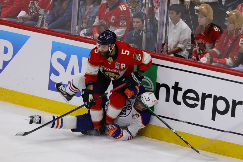Jun 10, 2024; Sunrise, Florida, USA; Florida Panthers defenseman Aaron Ekblad (5) boards Edmonton Oilers forward Connor McDavid (97) during the first period in game two of the 2024 Stanley Cup Final at Amerant Bank Arena. Mandatory Credit: Sam Navarro-USA TODAY Sports