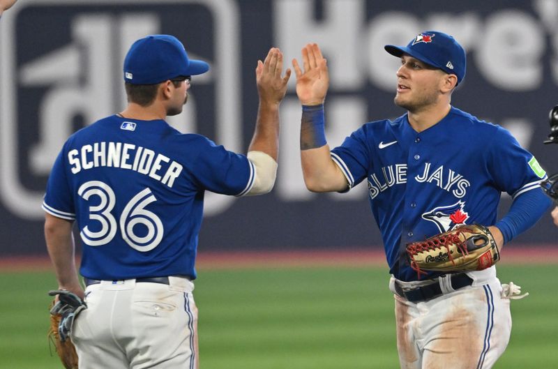 Aug 26, 2023; Toronto, Ontario, CAN;  Toronto Blue Jays second baseman Davis Schneider (36) and center fielder Daulton Varsho (25) celebrate after defeating the Cleveland Guardians at Rogers Centre. Mandatory Credit: Dan Hamilton-USA TODAY Sports