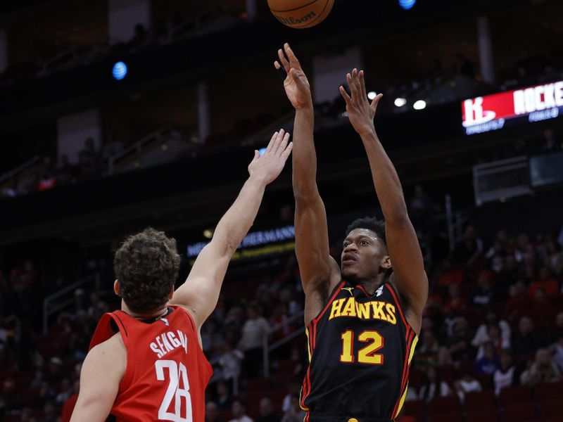 HOUSTON, TEXAS - DECEMBER 20: De'Andre Hunter #12 of the Atlanta Hawks shoots over Alperen Sengun #28 of the Houston Rockets during the first half at Toyota Center on December 20, 2023 in Houston, Texas. User expressly acknowledges and agrees that, by downloading and or using this photograph, User is consenting to the terms and conditions of the Getty Images License Agreement.?  (Photo by Carmen Mandato/Getty Images)