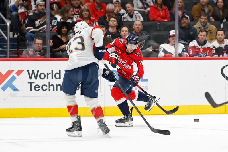 Jan 17, 2026; Washington, District of Columbia, USA; Washington Capitals center Connor McMichael (24) passes the puck as Florida Panthers center Carter Verhaeghe (23) defends during the third period at Capital One Arena. Mandatory Credit: Geoff Burke-Imagn Images