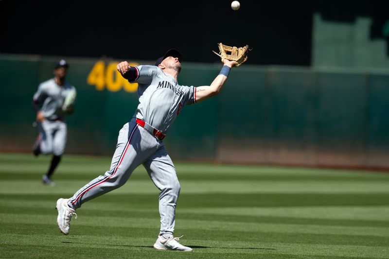 Jun 22, 2024; Oakland, California, USA; Minnesota Twins second baseman Kyle Farmer (12) catches of a popup to retire Oakland Athletics left fielder Miguel Andujar during the sixth inning at Oakland-Alameda County Coliseum. Mandatory Credit: D. Ross Cameron-USA TODAY Sports