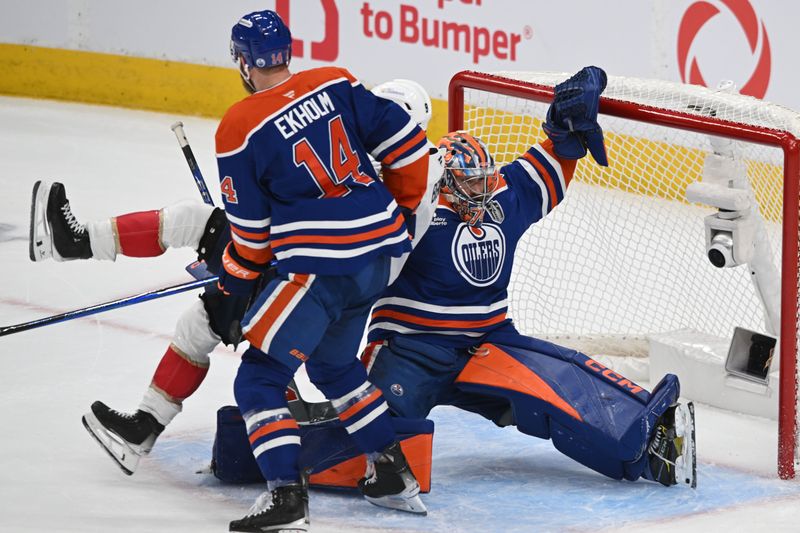 Jun 6, 2025; Edmonton, Alberta, CAN; Edmonton Oilers defenseman Mattias Ekholm (14) and goaltender Stuart Skinner (74) knock down Florida Panthers center Sam Bennett (9) during the first period in game two of the 2025 Stanley Cup Final at Rogers Place. Mandatory Credit: Walter Tychnowicz-Imagn Images